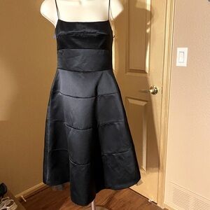 BCBG black satin paneled dress with crinoline at hem.